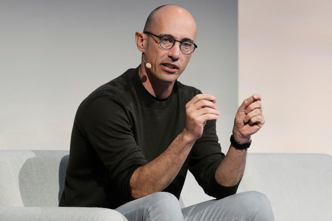 A man speaks into a headset while sitting.
