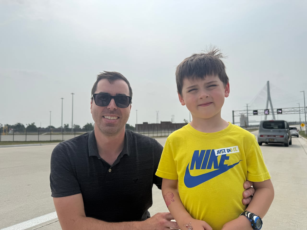 A man in a black shirt and a young boy in a yellow shirt