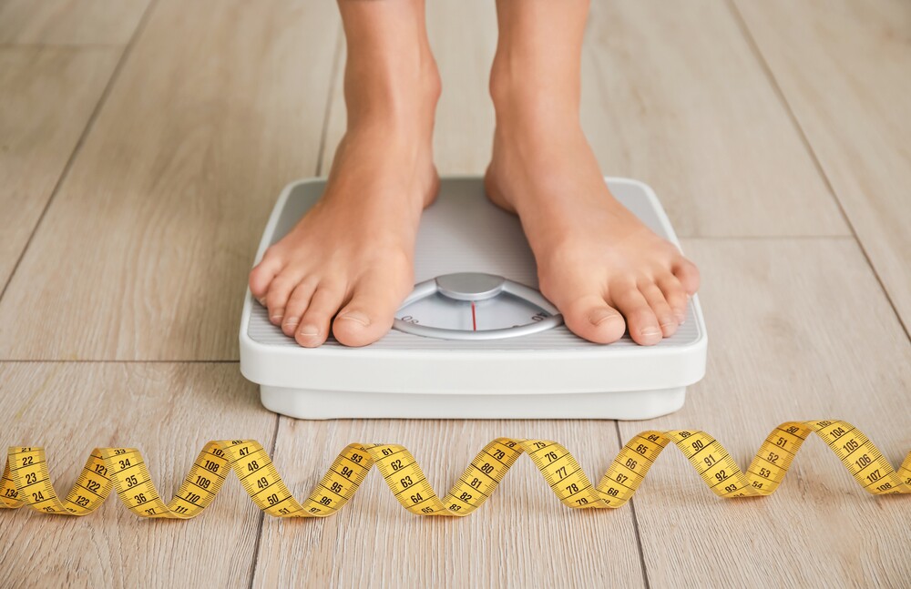Young,Woman,Measuring,Her,Weight,At,Home
