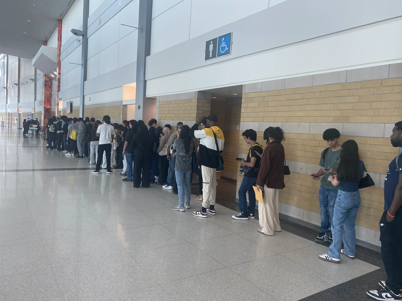 People lined up along the wall in a building.
