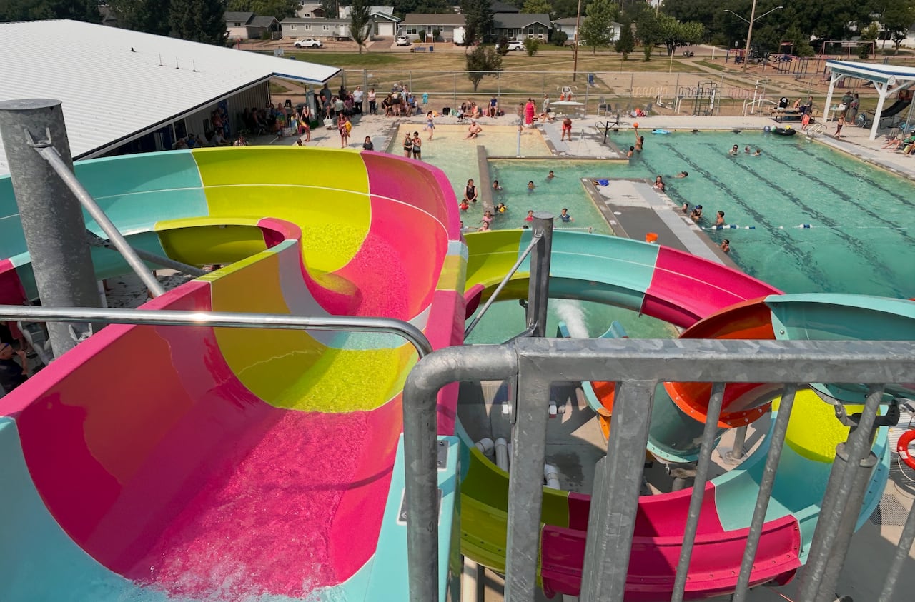 The view from the top of waterslides looking down on a pool on a beautiful summer day