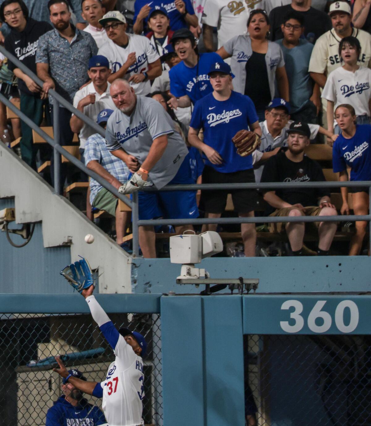 Teoscar Hernandez leaps to rob an extra-base hit from Seattle's Mitch Garver in the eighth inning Wednesday.