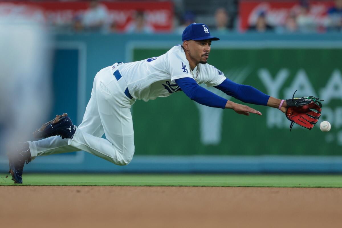Dodgers shortstop Mookie Betts dives for a ball hit by Seattle's Cole Young.