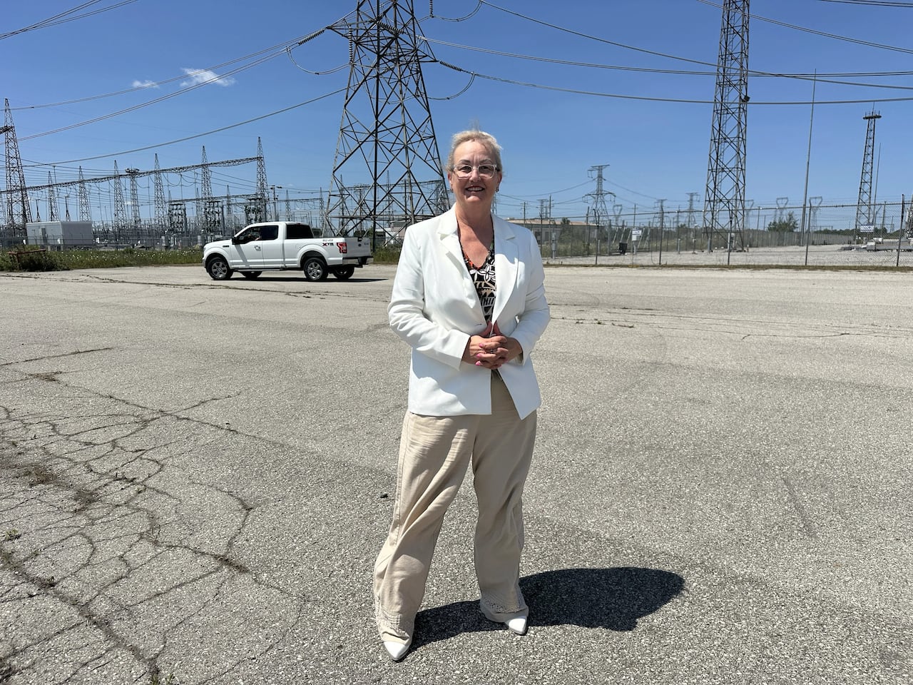 Woman in white jacket stands outside