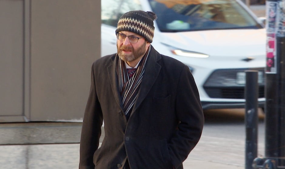 A man walking outside the courthouse on a cold day.