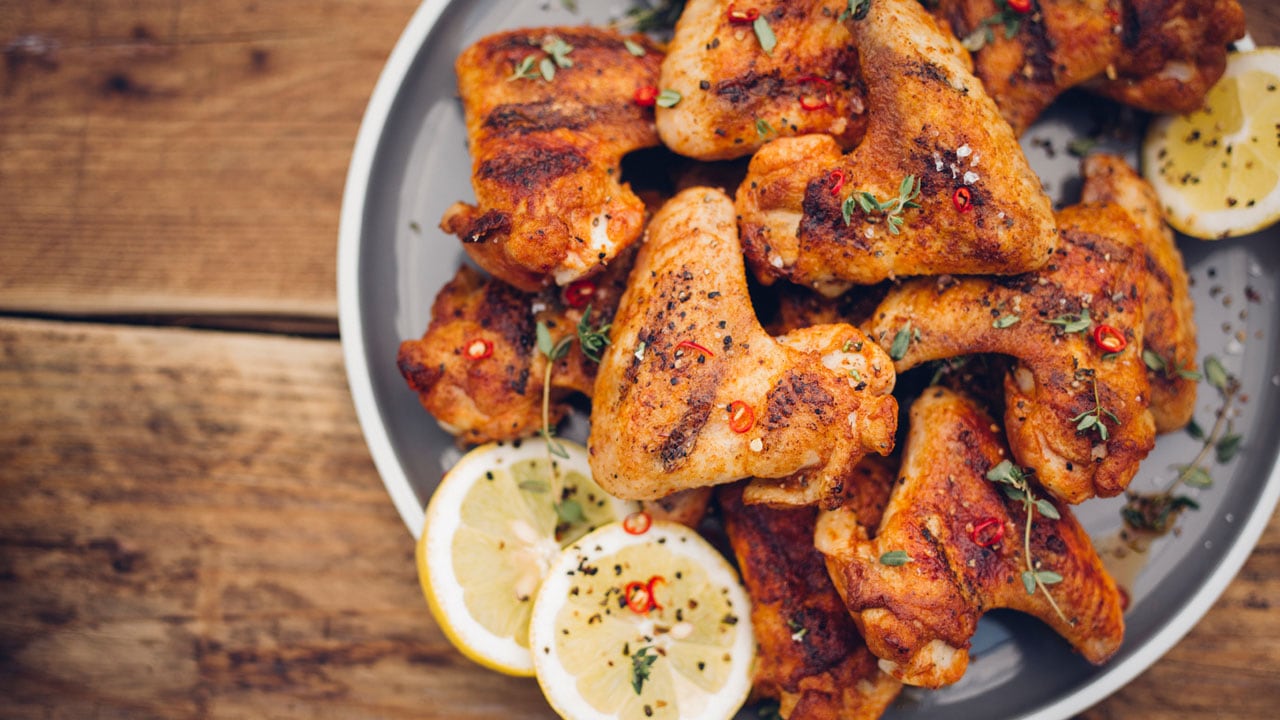 Closeup on a plate of marinated and grilled chicken wings.