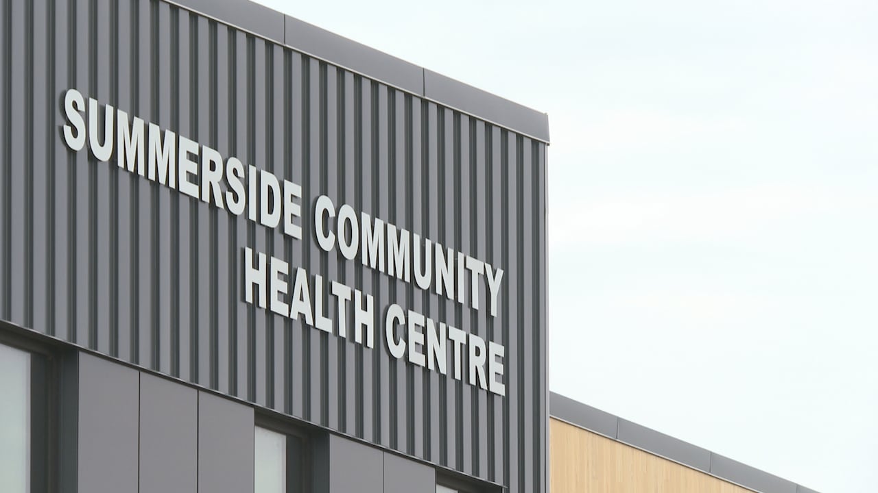A dark building is seen out the outside with white letters on its side.