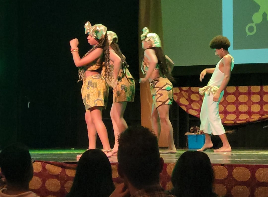 Dancers in Ghanaian costumes on a stage.