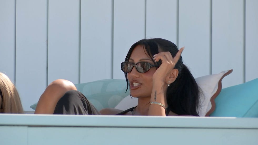 love island 2026 jasmine woman wearing sunglasses, relaxing and smiling while gesturing with her hand.