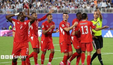 Referee Joao Pinheiro shows a red card to Breel Embolo of Switzerland as his teammate protest the decision