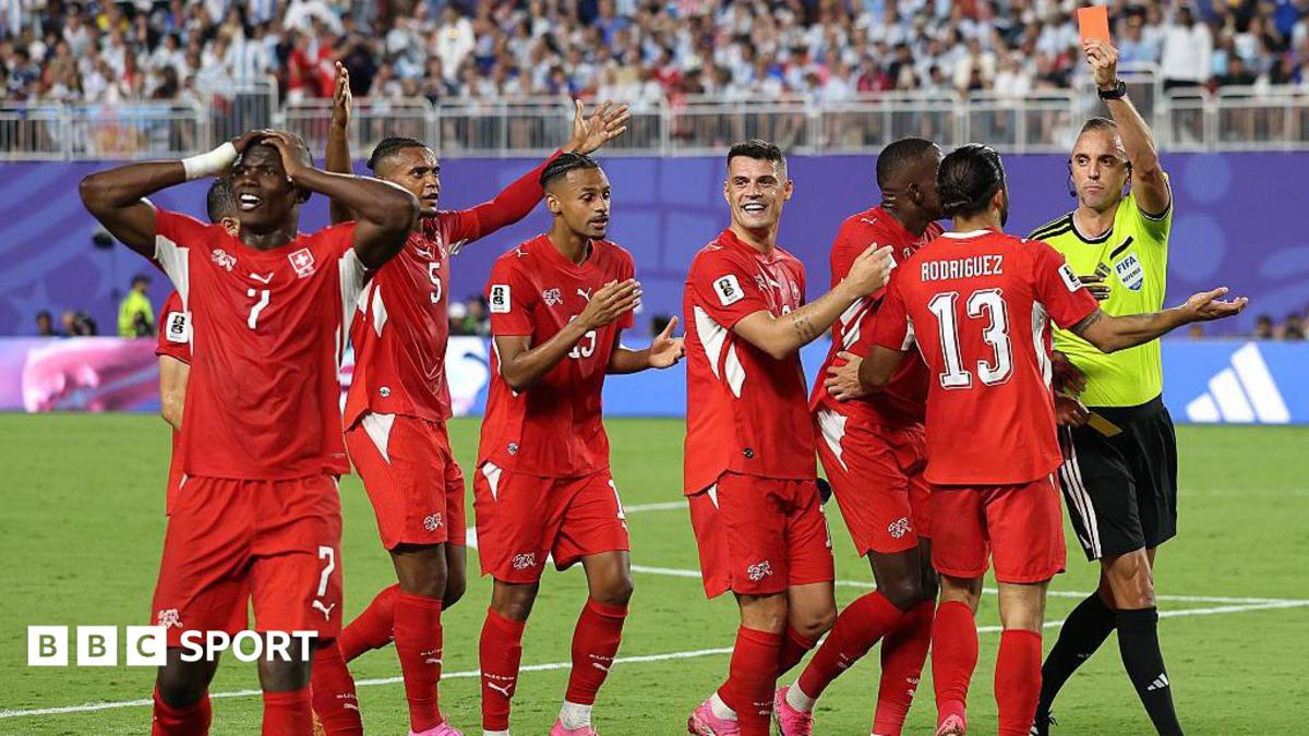 Referee Joao Pinheiro shows a red card to Breel Embolo of Switzerland as his teammate protest the decision