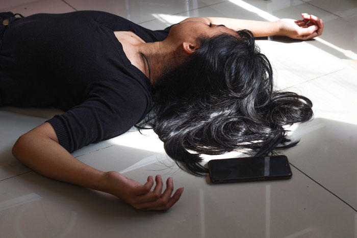 A patient lying unconscious on the floor next to a phone, failing to outsmart their doctors.