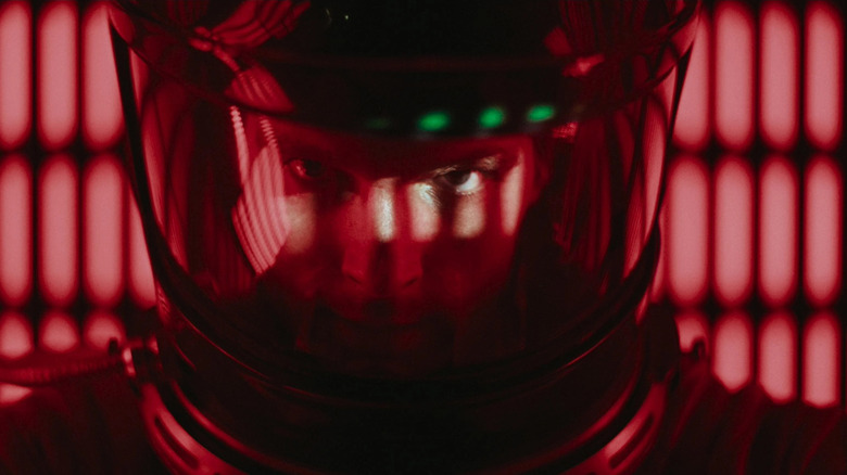 Keir Dullea as Dr David Bowman in 2001: A Space Odyssey, awash in red light in close-up inside his space suit, looking at the camera.