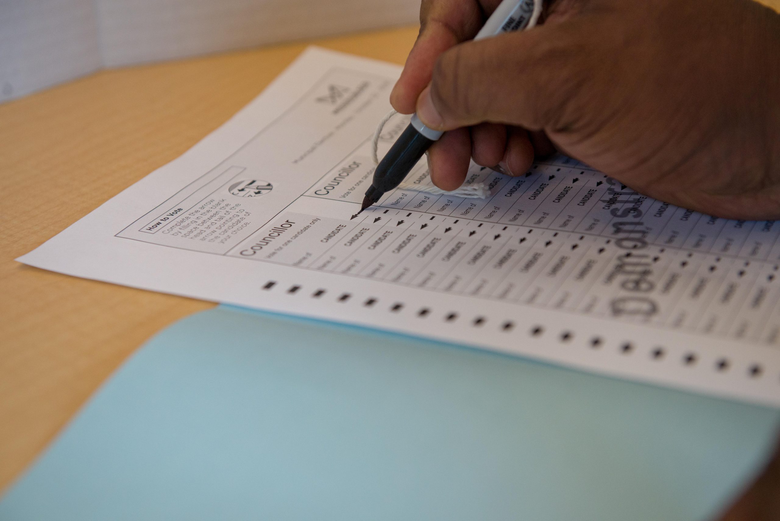 An election ballot being completed by a voter. 