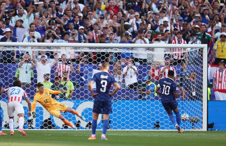 France's Kylian Mbappe scores their first goal past Paraguay's Orlando Gill from the penalty spot
