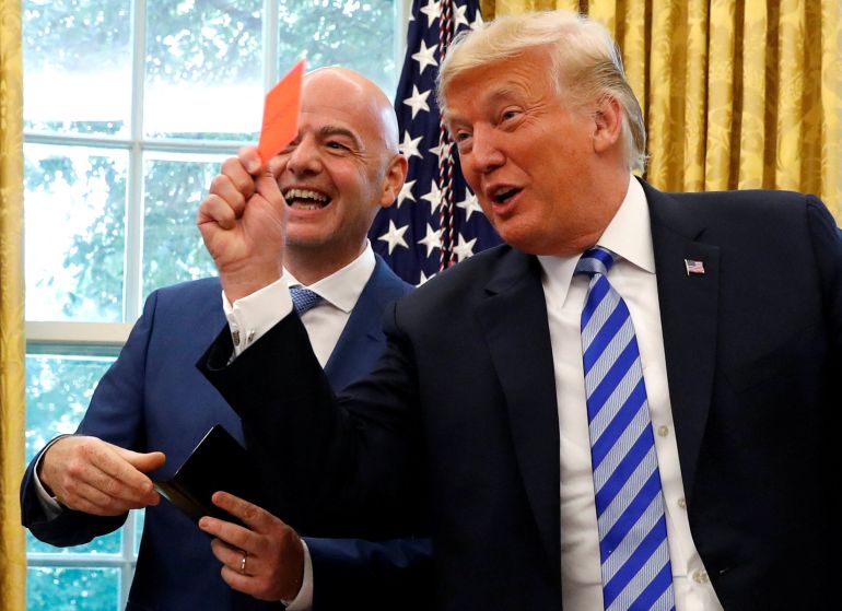 FILE PHOTO: U.S. President Donald Trump holds up a red card as he meets with FIFA President Gianni Infantino in the Oval Office of the White House in Washington, U.S., August 28, 2018. REUTERS/Leah Millis/File Photo