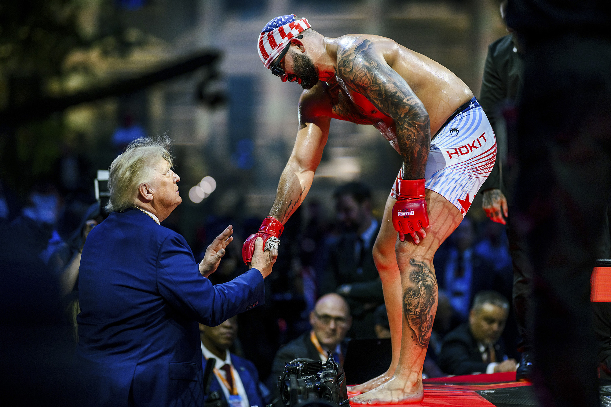 UFC fighter bending over to shake Donald Trump's hand.