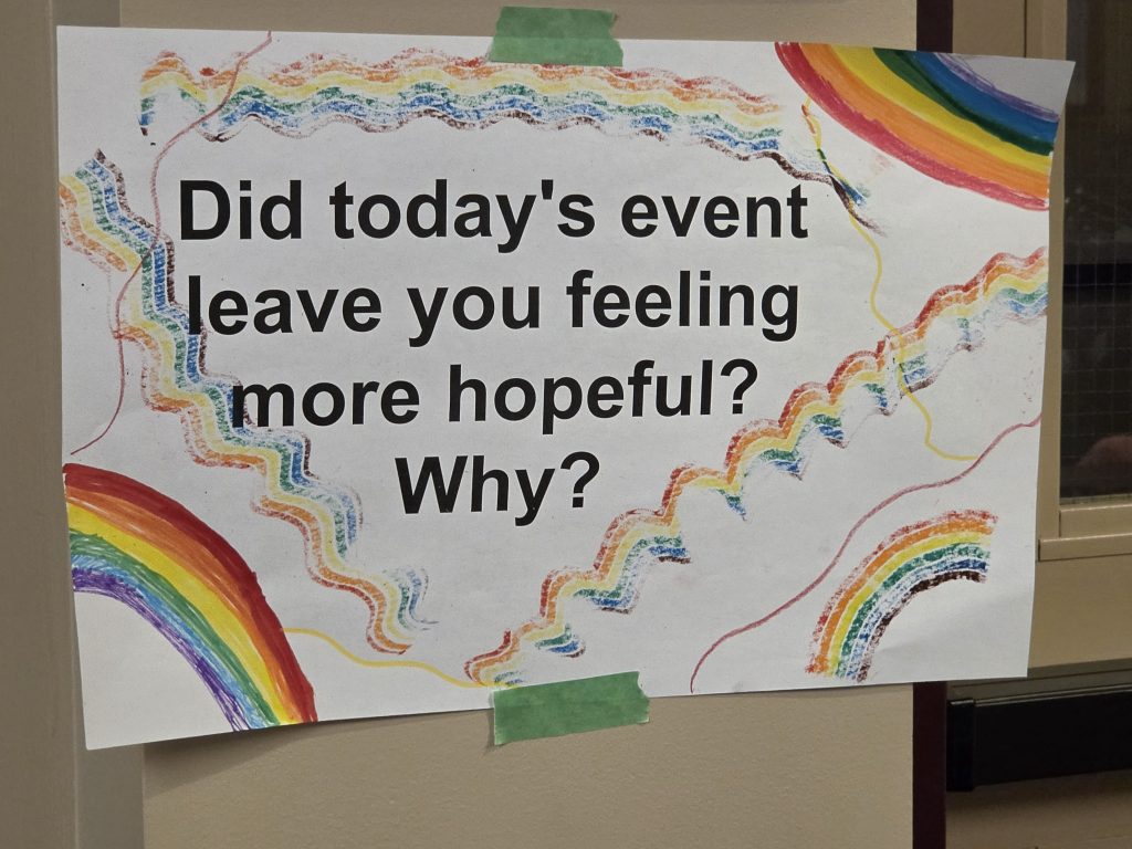 A sign featuring rainbows poses the question, "Did today's event leave you feeling more hopeful? Why?"