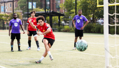 Students play soccer on a field.