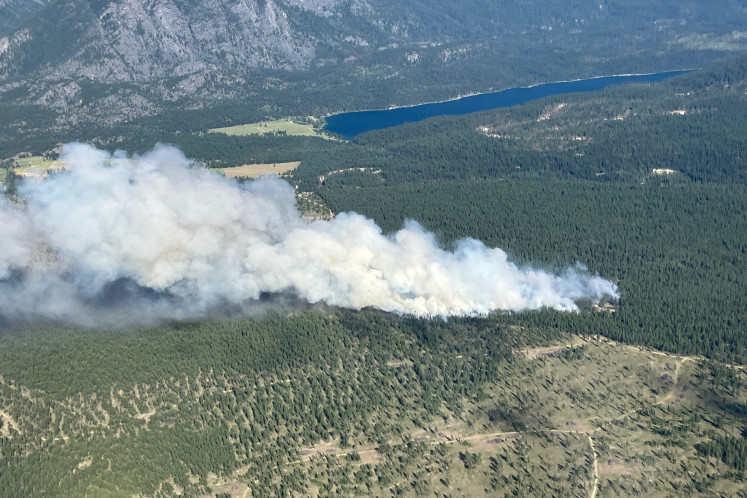 Smoke rises from the Lussier River Wildfire, north of Cranbrook, British Columbia, Canada on July 11, 2026 in an aerial photograph.