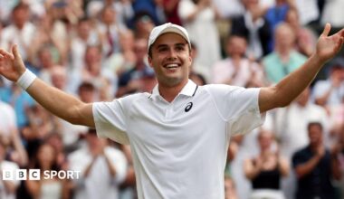 Flavio Cobolli applauds the Wimbledon crowd after his win over Alex de Minaur