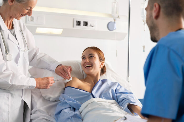 A female patient smiling while receiving an injection from a medical professional, highlighting medical industry truths.