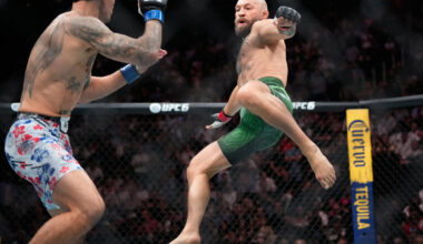Conor McGregor, right, jumps into the air for a kick as he fights Max Holloway in a welterweigh ...