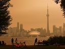 People look toward the downtown skyline from the Toronto Islands as forest fires in Northern Ontario cause poor air quality over the city on July 15, 2026. 