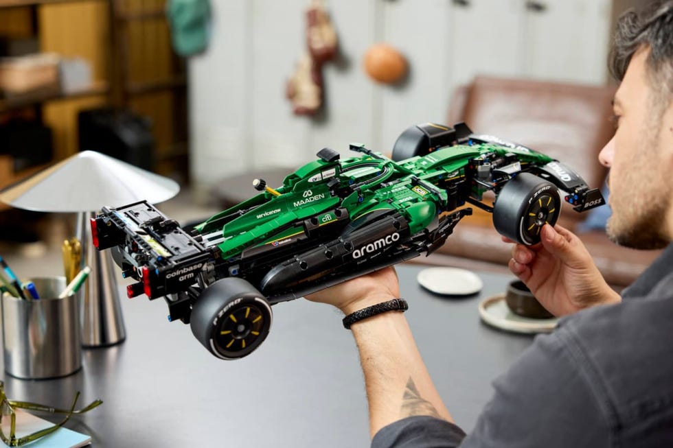 person holding the technic aston martin aramco amr25 f1 car