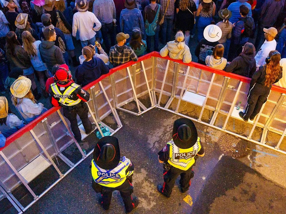 Members of the Calgary Police Service, along with private security and a paramedic, monitor crowds at the Coca-Cola Stage on Stampede Grounds on July 10, 2025.