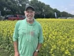 Jarret Chambers, president of ATP Nutrition, stands near a canola plot at Ag In Motion 2026. Photo: Gord Gilmour