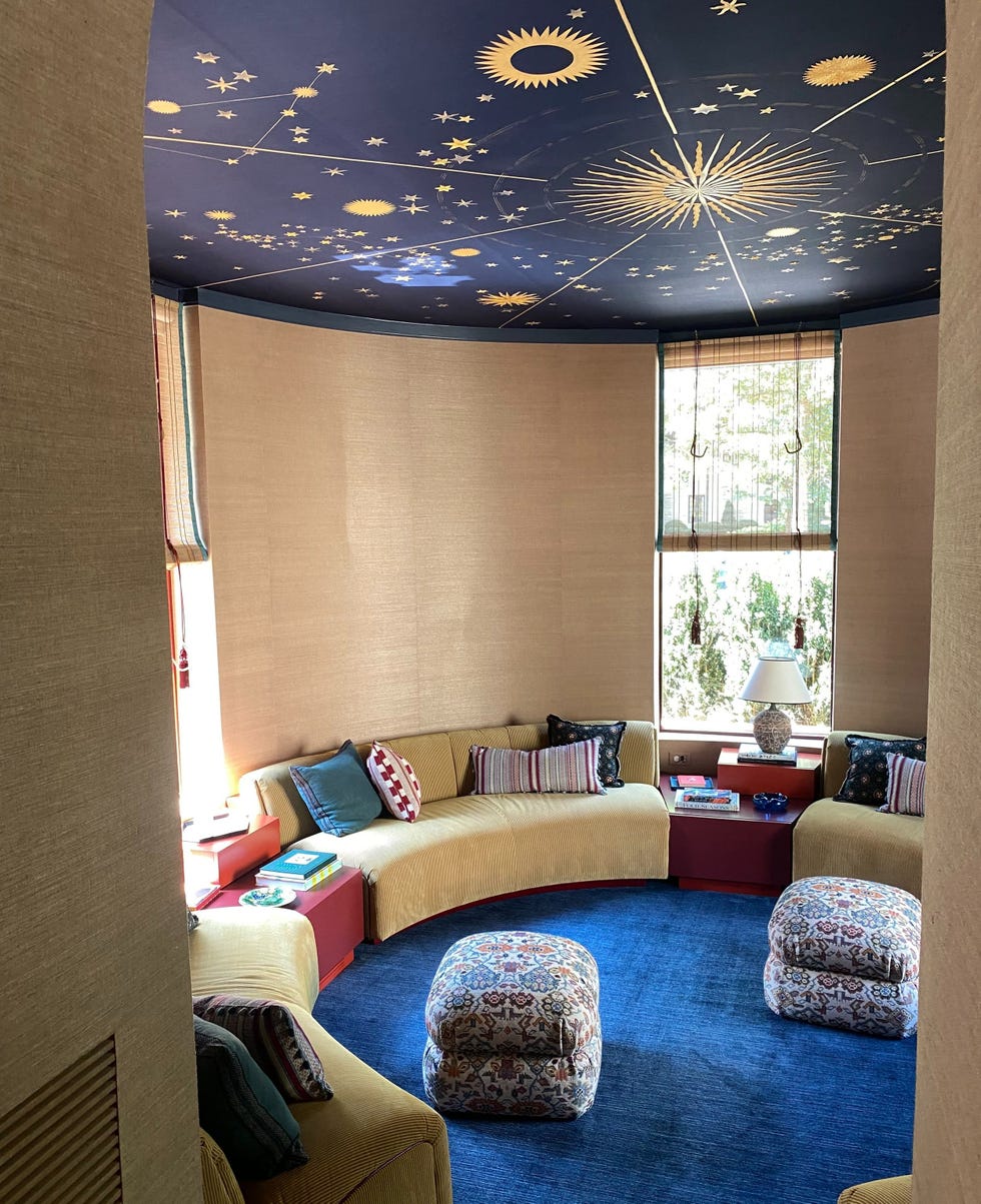 Cozy circular seating area with a starry blue ceiling, colorful cushions, and a warm atmosphere.