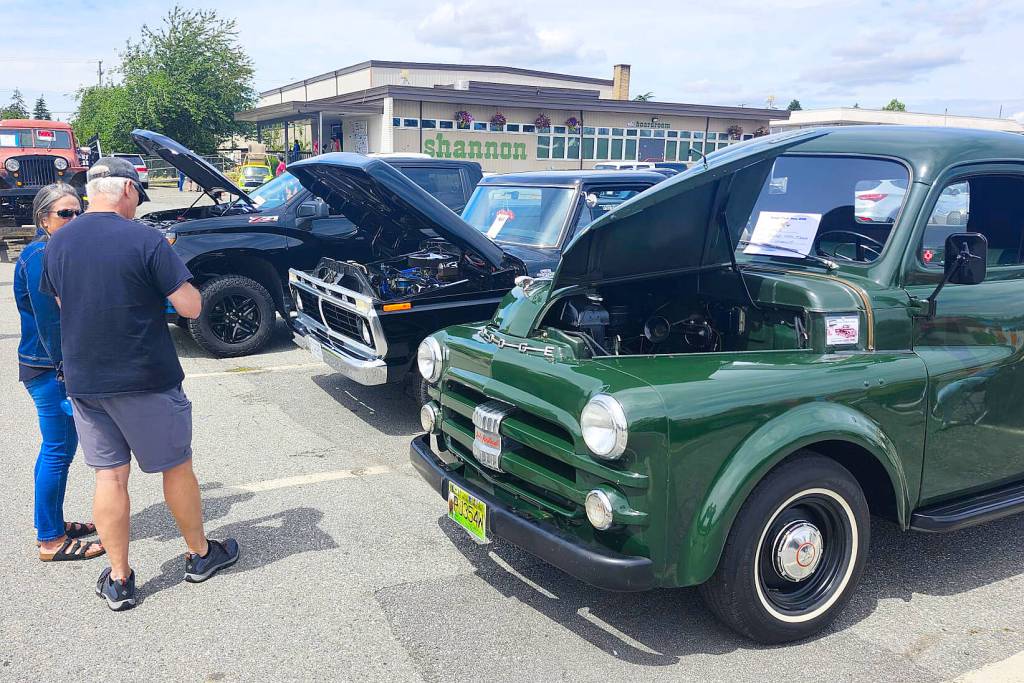 Show-goers inspect a green 1953 Dodge truck and a black 1977 Ford pickup at the Truck Show, held July 11 at the B.C. Vintage Truck Museum. (Photo: Malin Jordan/Cloverdale Reporter)