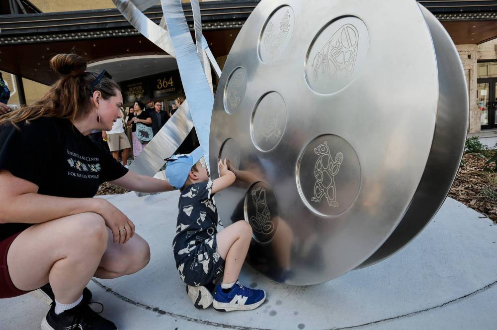 JOHN WOODS / FREE PRESS
Alie and her son Teddy look at the new public art piece, Gather Your Heart.