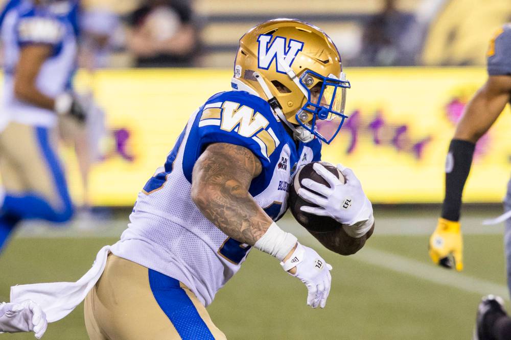 Winnipeg Blue Bombers’ Brady Oliveira (20) runs the ball during second half CFL football action against the Hamilton Tiger-Cats, in Hamilton on Sunday, July 5, 2026. (Nick Iwanyshyn / The Canadian Press)