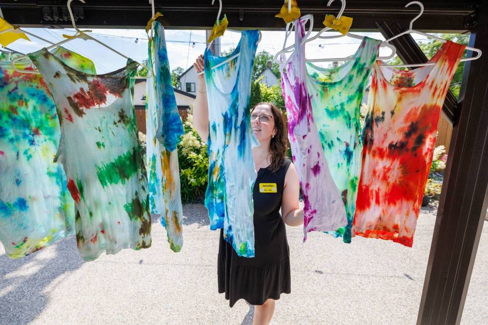 MIKE DEAL / FREE PRESS
Recreation director Jennifer Russell examines some of the tie-dyed shirts residents made during a recent activity session.
