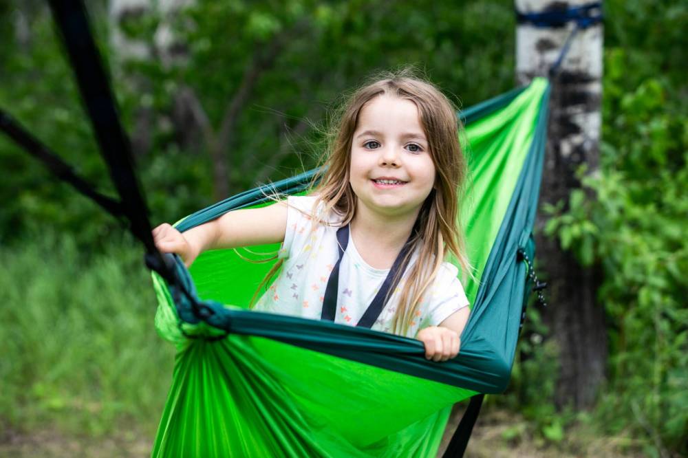MIKAELA MACKENZIE / FREE PRESS
Lauriane Bellefeuille, 5, hangs out in a hammock as music gets underway on the main stage.