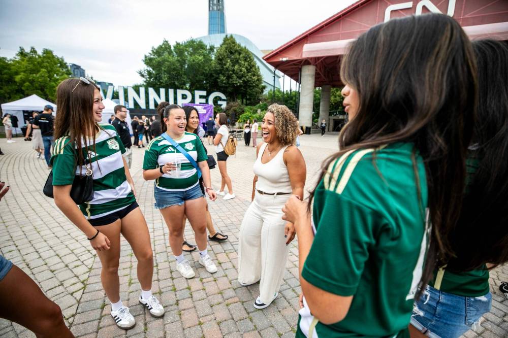 MIKAELA MACKENZIE / FREE PRESS
NSL Winnipeg expansion team co-founder Desiree Scott (right) laughs with FC Northwest League U17 girls players Bre Horn (left) and Lyla Lagimodiere at The Forks on Tuesday.