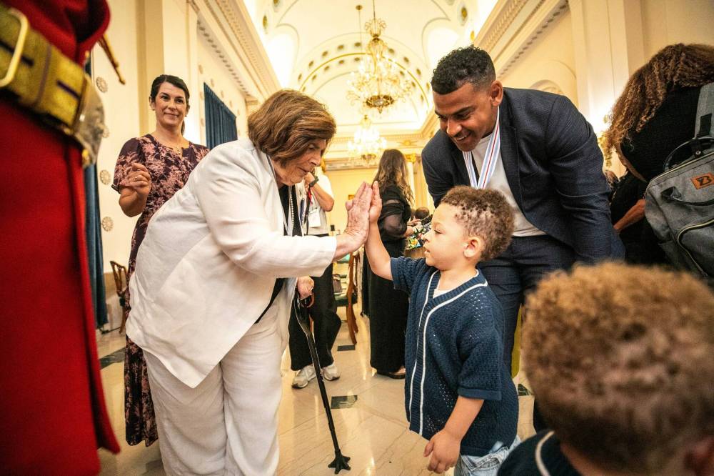 MIKAELA MACKENZIE / FREE PRESS
Lieutenant governor Anita Neville (left) high-fives Axton Harris, age three, after his dad, Andrew Harris, was awarded the Order of Manitoba at the Manitoba Legislative Building on Thursday.