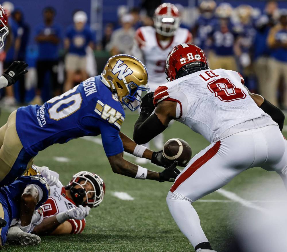 JOHN WOODS / THE CANADIAN PRESS
Winnipeg Blue Bombers receiver Ontaria Wilson (left) intercepts the lateral pass from Calgary Stampeders’ Ben Labrosse (29) intended for Marquel Lee (8) on Friday.