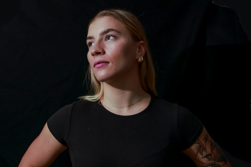 A blonde woman in a dark shirt.