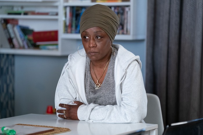 566671,TITLE:Eastenders Denise wearing a green head wrap and a white hoody in a scene from EastEnders