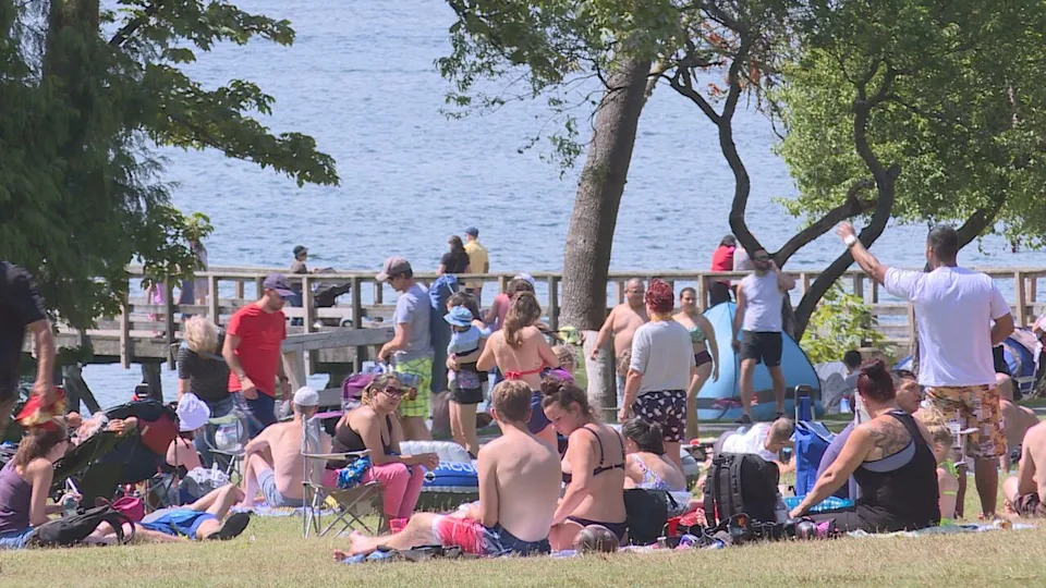 Picnicers sit beside the lake in Belcarra B.C.