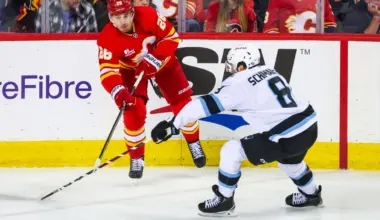 Calgary Flames defenseman Zach Whitecloud (28) controls the puck against Utah Mammoth center Nick Schmaltz (8) during the second period at Scotiabank Saddledome.