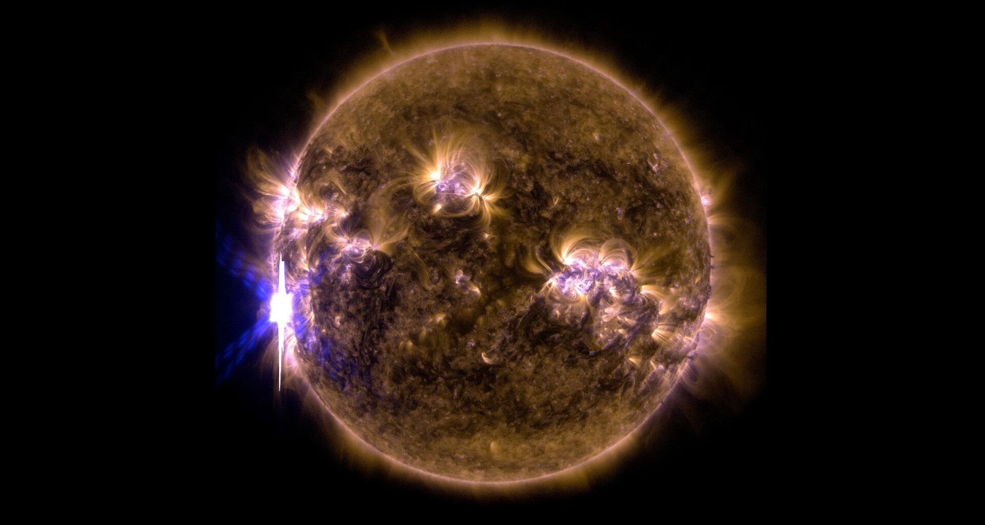 A filtered sun that's yellow and purple. A solar flare is visible to the left.