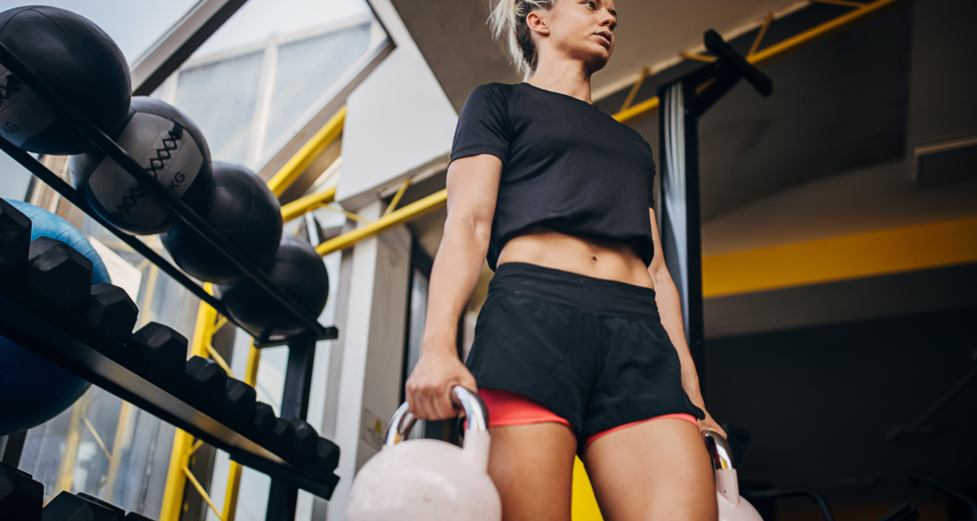 A woman performing kettlebell loaded carries