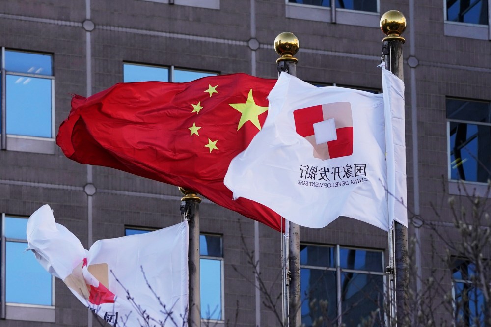 FILE - Flags of the China Development Bank are flown near a Chinese flag outside a subsidiary branch office of the Bank in Beijing, Jan. 8, 2021. (AP Photo/Ng Han Guan, File)