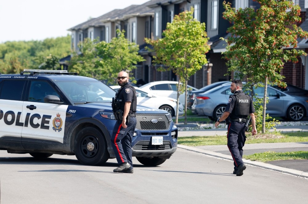 Police members walk on the street where two children were found dead in their home in the Findlay Creek neighbourhood of Ottawa on Monday, June 29, 2026. THE CANADIAN PRESS/Patrick Doyle