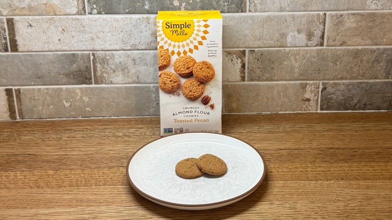 Simple Mills Toasted Pecan Cookies in a box with two cookies on a plate in front