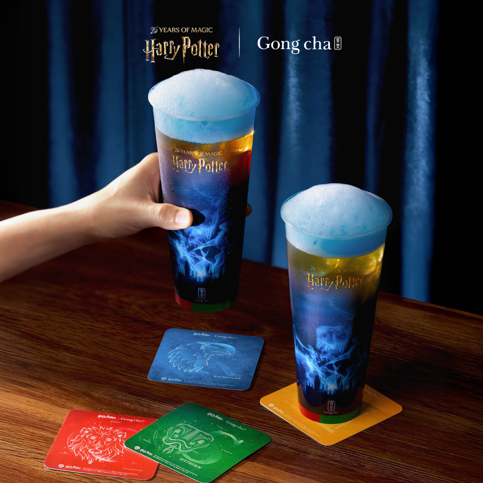 Two colorful drinks with foam, Harry Potter-themed coasters on a wooden table. Two colorful drinks with foam, Harry Potter-themed coasters on a wooden table.